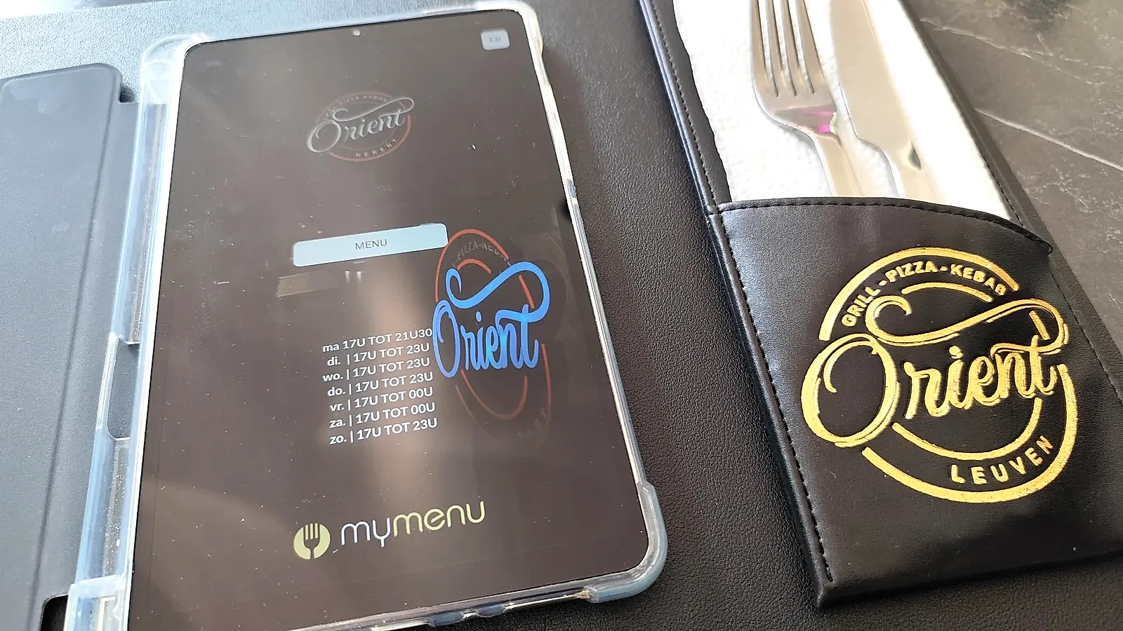Het Orient-logo op het tafelmenu, in goud op zwart leer